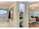 Hallway with built-in shelving adjacent to a full bathroom, leading to a bedroom with a decorative chandelier at 5395 Lake Arrowhead Trl # 24, Sarasota, FL 34231
