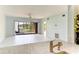 Open living room with tranquil water view from kitchen pass-through window at 5395 Lake Arrowhead Trl # 24, Sarasota, FL 34231