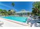 Community pool with a pavilion, lounge chairs, and tables, ideal for relaxation and socializing at 5395 Lake Arrowhead Trl # 24, Sarasota, FL 34231