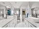 Bright, all-white bathroom featuring double sinks, marble countertops, and a glass-enclosed shower at 548 Beach Rd # 540A, Sarasota, FL 34242