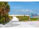 Sandy path leads to Siesta Beach, ranked #1, bordered by lush greenery and featuring a view of the ocean at 548 Beach Rd # 540A, Sarasota, FL 34242