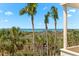 Elevated beach view showcasing palm trees, native plants, and the sparkling ocean in the distance at 548 Beach Rd # 540A, Sarasota, FL 34242