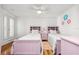 Charming bedroom features two twin beds, white walls with flower accents, and a fan at 548 Beach Rd # 540A, Sarasota, FL 34242