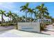 The Siesta Beach sign welcomes visitors with swaying palm trees and clear blue skies near the park entrance at 548 Beach Rd # 540A, Sarasota, FL 34242
