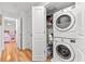 Efficient laundry room with a stacked washer and dryer and convenient storage shelves at 548 Beach Rd # 540A, Sarasota, FL 34242