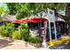 Exterior view of a restaurant featuring outdoor seating, shade umbrellas, and lush greenery in a beach setting at 548 Beach Rd # 540A, Sarasota, FL 34242