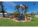 Community entrance featuring a decorative sign, American flag, and lush landscaping, welcoming residents at 606 Emerald Ln, Holmes Beach, FL 34217