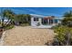 Charming home with a patio, lush landscaping, and a gravel yard, creating a serene outdoor space at 606 Emerald Ln, Holmes Beach, FL 34217