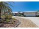 Charming one-story home featuring an attached garage, unique front door, and tropical landscaping at 606 Emerald Ln, Holmes Beach, FL 34217