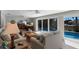 Cozy living room features comfortable seating and a view of the backyard pool at 606 Emerald Ln, Holmes Beach, FL 34217