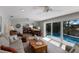 Comfortable living room with neutral decor and a view of the backyard pool and canal at 606 Emerald Ln, Holmes Beach, FL 34217