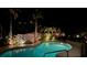 Inviting pool area at night with illuminated landscaping, creating a relaxing outdoor retreat at 606 Emerald Ln, Holmes Beach, FL 34217