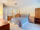 Bright bedroom featuring wood furniture, large bed with blue geometric pattern at 6102 Penny Ln, Bradenton, FL 34207