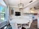 Cozy dining area with a view of the kitchen, featuring white cabinets and modern appliances at 6102 Penny Ln, Bradenton, FL 34207