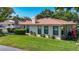 Charming single-story home with a well-manicured lawn and a classic chimney, surrounded by lush greenery at 6102 Penny Ln, Bradenton, FL 34207