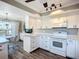 Well-lit kitchen with white appliances, ample counter space, and hardwood-style flooring at 6102 Penny Ln, Bradenton, FL 34207