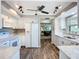 Spacious kitchen with white cabinets, modern lighting, and hardwood floors throughout the area at 6102 Penny Ln, Bradenton, FL 34207