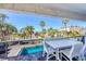 Scenic balcony with a dining table and chairs, overlooking the pool and tropical surroundings at 625 Beach Rd # 207, Sarasota, FL 34242