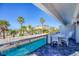 Beautiful view from the condo balcony overlooking pool, palm trees, beach, and clear blue sky at 625 Beach Rd # 207, Sarasota, FL 34242