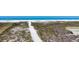 Overhead view of a sandy beach path bordered by natural dunes, leading to a scenic beach and the ocean at 625 Beach Rd # 207, Sarasota, FL 34242