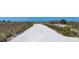 Sandy path leading to a serene beach, bordered by natural dunes and lush vegetation at 625 Beach Rd # 207, Sarasota, FL 34242