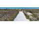 Scenic sandy path leading to a pristine beach, surrounded by natural dunes and vegetation at 625 Beach Rd # 207, Sarasota, FL 34242