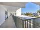 Long condo hallway with great lighting, flower pots, and views of the complex's parking area at 625 Beach Rd # 207, Sarasota, FL 34242