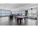 Spacious living room with a pool table and breathtaking ocean views from the large windows at 625 Beach Rd # 207, Sarasota, FL 34242