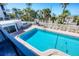 A cozy pool with lounge chairs and beach access surrounded by lush landscaping and a white fence at 625 Beach Rd # 207, Sarasota, FL 34242