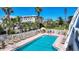 Inviting pool area with ample lounge chairs, palm trees, and a glimpse of the surrounding neighborhood at 625 Beach Rd # 207, Sarasota, FL 34242