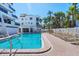 Beautiful swimming pool with clear blue water, surrounded by lounge chairs and palm trees at 625 Beach Rd # 207, Sarasota, FL 34242