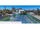 Aerial view of well maintained tennis courts surrounded by lush landscaping and a clear blue sky at 625 Beach Rd # 207, Sarasota, FL 34242