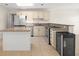 Open kitchen with stainless appliances, granite counters, island, and wine cooler at 6732 Washington Pl, Bradenton, FL 34207