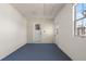 Empty room shows door to outside, window, and blue floor at 6732 Washington Pl, Bradenton, FL 34207