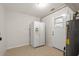 Utility room includes a refrigerator, hot water heater, and exterior door at 6732 Washington Pl, Bradenton, FL 34207