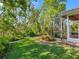 Landscaped backyard featuring lush lawn, tropical plants, and a screened lanai for outdoor enjoyment at 6748 Hickory Hammock Cir, Bradenton, FL 34202