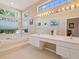 Bright bathroom with double sinks, a large mirror, and a relaxing tub with a view of the outdoors at 6748 Hickory Hammock Cir, Bradenton, FL 34202