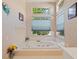 Serene bathroom features a spacious jacuzzi tub surrounded by tile, offering a relaxing retreat with natural light at 6748 Hickory Hammock Cir, Bradenton, FL 34202