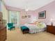 Cozy bedroom featuring a floral-themed bed set, complemented by a green accent chair and soft carpet at 6748 Hickory Hammock Cir, Bradenton, FL 34202