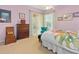 Comfortable bedroom showcases a vibrant floral bed set, accented by a stylish turquoise chair and a wooden dresser at 6748 Hickory Hammock Cir, Bradenton, FL 34202
