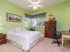 Inviting bedroom with green walls, a cozy bed, and a classic wooden dresser, offering a peaceful retreat at 6748 Hickory Hammock Cir, Bradenton, FL 34202