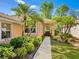 Welcoming front entrance with mature tropical landscaping leading to a tiled-roof home at 6748 Hickory Hammock Cir, Bradenton, FL 34202