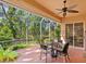 Spacious screened-in patio features a cozy dining set, perfect for enjoying the lush outdoor views at 6748 Hickory Hammock Cir, Bradenton, FL 34202