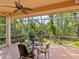 Inviting screened-in patio with a ceiling fan and a table set, perfect for outdoor dining and relaxation at 6748 Hickory Hammock Cir, Bradenton, FL 34202