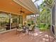 Enjoy outdoor dining on this covered patio with wicker furniture and fan, leading to a screened lanai at 6748 Hickory Hammock Cir, Bradenton, FL 34202
