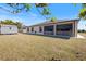 Private backyard with lush green lawn and a screened-in patio, ideal for outdoor living at 7145 Mamouth St, Englewood, FL 34224