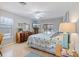 Bright bedroom featuring a beach-themed quilt, dresser, and sliding glass doors to the lanai at 7145 Mamouth St, Englewood, FL 34224