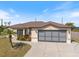 Well-maintained single-story home with a two-car garage and mature landscaping on a sunny day at 7145 Mamouth St, Englewood, FL 34224