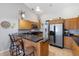 Modern kitchen with breakfast bar seating, wood cabinets, and stainless steel appliances at 7145 Mamouth St, Englewood, FL 34224