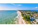 Scenic aerial view of the coastline with sandy beach, turquoise water, and charming waterfront homes at 7705 Grand Estuary Trl # 202, Bradenton, FL 34212